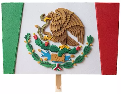 Bandera mexicana decorativa hecha con papel texturizado, con el escudo nacional y una base de madera tipo paleta