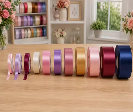 Rollos de listón satinado de distintos colores sobre una mesa de madera